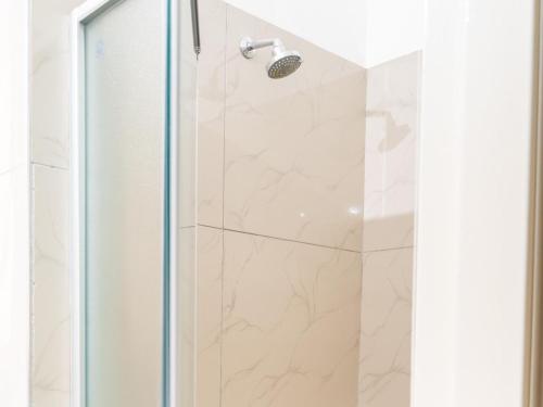a shower in a bathroom with a glass door at Ngwenya City Hotel in Klerksdorp