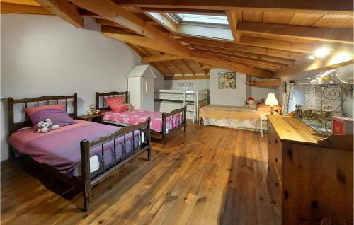 2 letti in una camera con pavimenti in legno di Gorgeous Home In Bas-en-basset With Kitchen a Bas-en-Basset