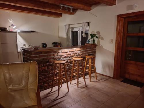 a kitchen with a bar with stools and a brick wall at Bieszczadzki Kąt in Lesko