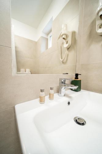 a bathroom with a white sink and a mirror at Lilla Panzió in Odorheiu Secuiesc