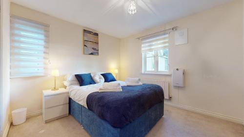 um quarto com uma cama grande e um cobertor azul em Impeccable 4-Bed House in London em Londres