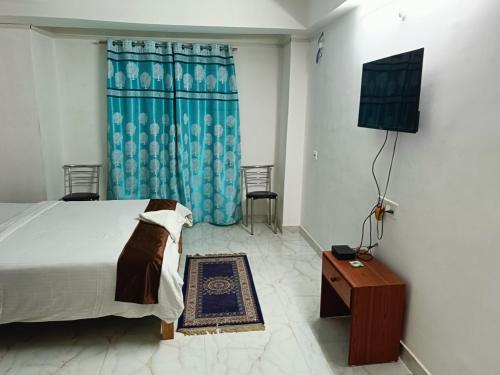 a bedroom with a bed and a television in it at HOTEL ATITHI GRAND in Guwahati