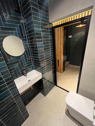 a bathroom with a sink and a toilet and a mirror at The Hideaway, Hot Tub in Henley in Arden