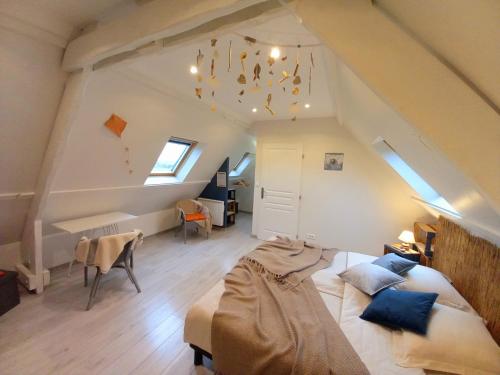 a bedroom with a large bed in a attic at chambres d'hôtes Au Gré du Vent en Normandie in Malleville-les-Grès