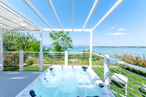 a hot tub on a deck with a view of the water at San Benedetto Camping Relais in Peschiera del Garda