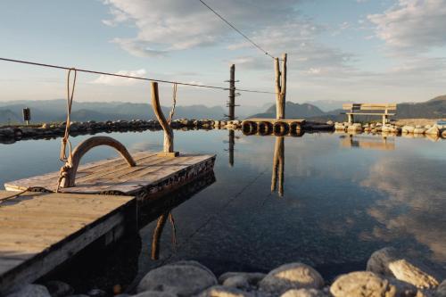 a body of water with a dock in the water at SportLodge GOLF SUITE - Cozy Apartment with Shared Pool, Whirlpool & Sauna, presented by AlpenLuxus in Kleinboden