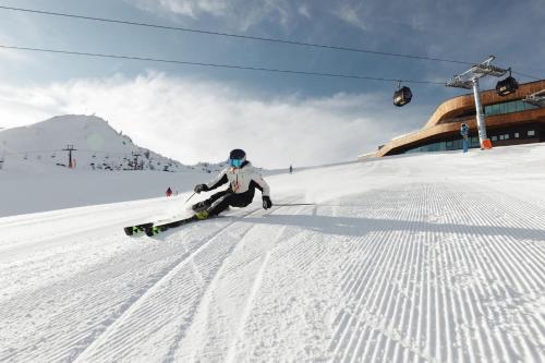 a person is skiing down a snow covered slope at SportLodge GOLF SUITE - Cozy Apartment with Shared Pool, Whirlpool & Sauna, presented by AlpenLuxus in Kleinboden
