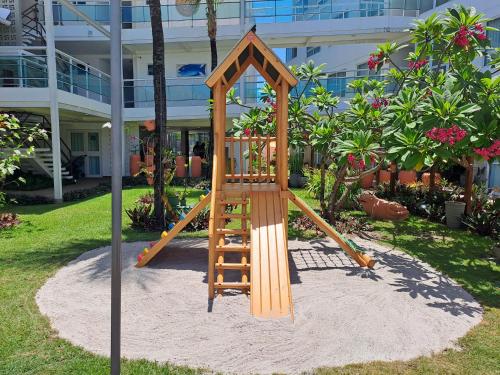 a wooden playground with a slide in a yard at Hotel Vivenda dos Corais in Porto De Galinhas