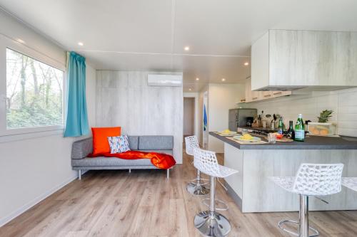 a kitchen with a couch and chairs in a room at San Benedetto Camping Relais in Peschiera del Garda