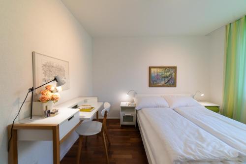 - une chambre avec un lit et un bureau avec une lampe dans l'établissement Rietgarten, à Wildhaus