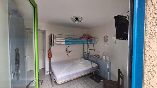 Cette petite chambre comprend des lits superposés et une douche. dans l'établissement Mas bleu île des pêcheurs, au Barcarès