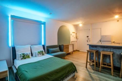 Cet appartement comprend une chambre avec un lit et une cuisine avec un bar. dans l'établissement Le Hyérois Studio, à Hyères