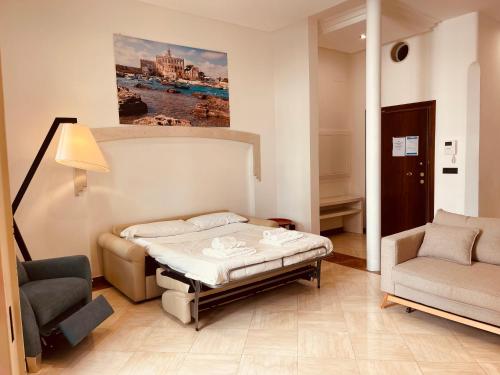 a bedroom with a bed and a couch and a chair at Putignani Exclusive Suite in Bari