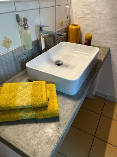 a white sink sitting on a counter with a yellow towel at Casa-Catalina in Heddesheim