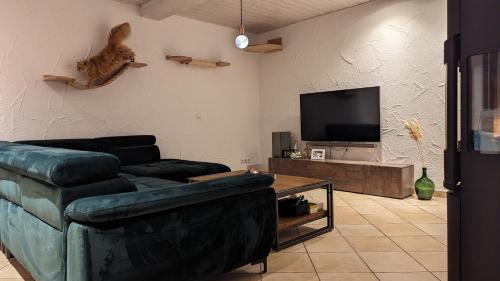 a living room with a couch and a cat on the wall at Kleines gemütliches Haus auf dem Land in Linsengericht