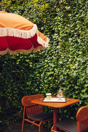 a table and chairs in front of a green wall at Eight Hotel Portofino in Portofino