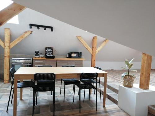 uma cozinha com uma mesa de madeira e cadeiras em Sielskie Klimaty em Marcinowice