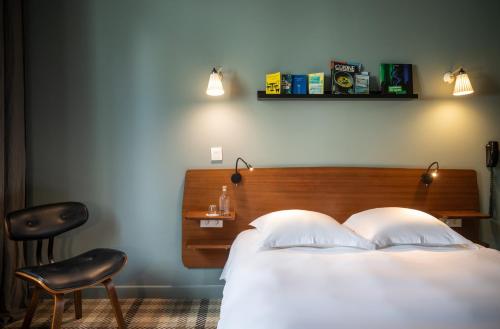 a bedroom with a bed and a chair and a desk at Hotel Beaulieu Lyon Charbonnières in Charbonnières-les-Bains