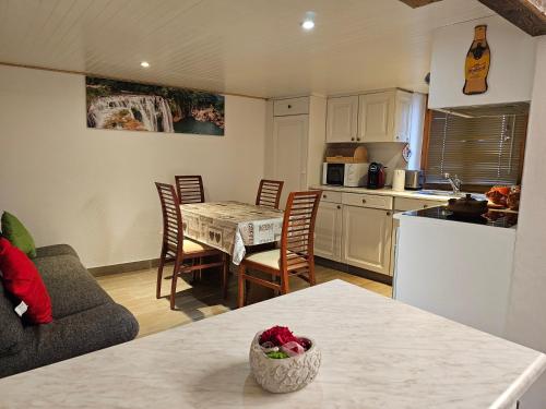 a kitchen and living room with a table and chairs at Joli appartement au cœur du village in Orsières