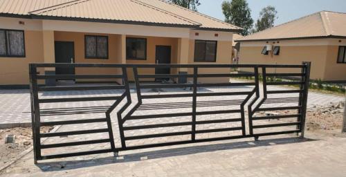 a black gate in front of a house at Peaceful Hills Self Catering Holiday House in Lusaka