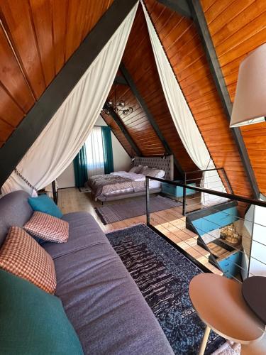 - un salon avec un canapé et un lit dans le grenier dans l'établissement Cottage Veranda, à Kazbegi