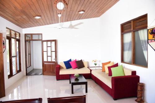 a living room with two couches with colorful pillows at SaRu Holiday Apartment - Upto 6 Guests in Kandy
