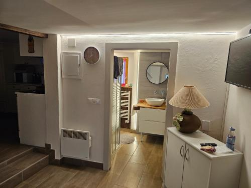 a kitchen with a hallway with a sink and a table at Joli appartement au cœur du village in Orsières