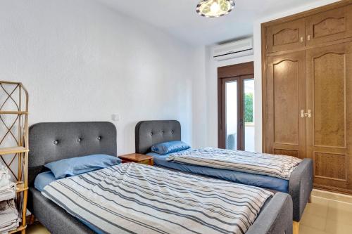 dwa łóżka siedzące obok siebie w pokoju w obiekcie Ruhiges Eckreihenhaus mit Pool w mieście Pedreguer