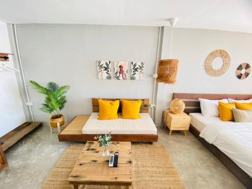 uma sala de estar com 2 camas e uma mesa de centro em เรือนตะวัน เกาะล้าน RueanTawan Kohlarn em Ko Larn