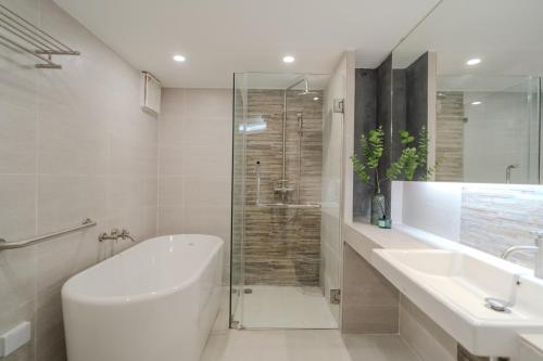La salle de bains est pourvue d'une baignoire, d'un lavabo et d'une douche. dans l'établissement Mini Jung Nimmari, à Chiang Mai