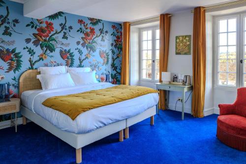1 dormitorio con 1 cama y 1 silla roja en L’Auberge du Château, en Dampierre