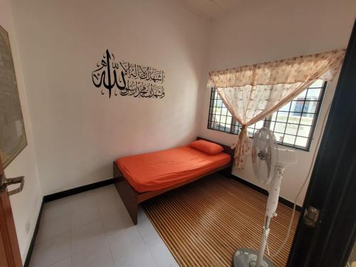 a small room with a bed with a window at Homestay Melor Serendah in Serendah