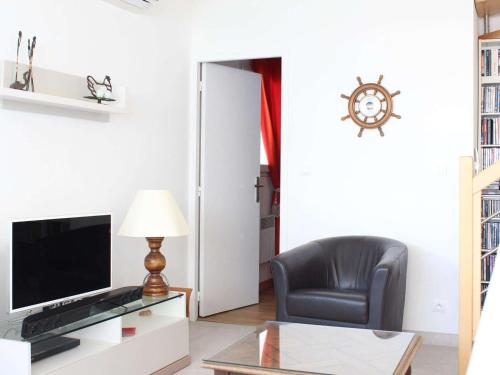 un salon avec une chaise et une télévision dans l'établissement Maison 3 niveaux, 6 couchages, La Baule, proche plage et commerces, terrasses privées - FR-1-245-150, à La Baule