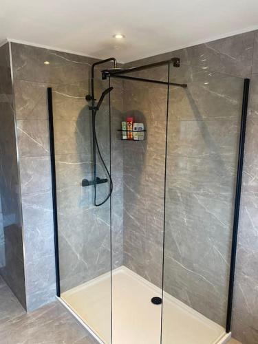 um chuveiro com uma porta de vidro na casa de banho em Mountainview lodge With Hot tub/ Mancave/Pool room em Kilcoo