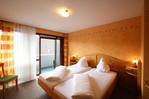 a hotel room with two beds and a window at Hotel-Gasthof Hirschen in Blumberg