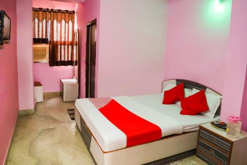 Un dormitorio con una cama con almohadas rojas. en OYO 45569 Goyal's Inn, en Ajmer