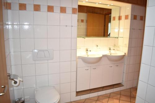 een badkamer met 2 wastafels en een toilet bij Tgamutsch (461 Tä) in Lenzerheide