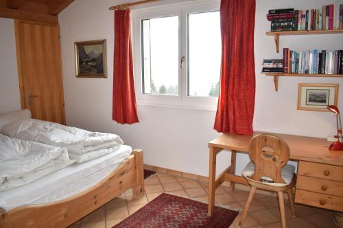 een slaapkamer met een bed, een bureau en een stoel bij Tgamutsch (461 Tä) in Lenzerheide