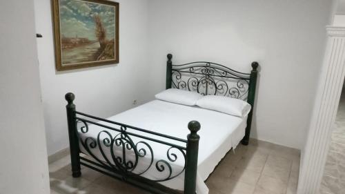 uma cama preta num quarto com uma fotografia na parede em Apartamento en Ibague em Ibagué