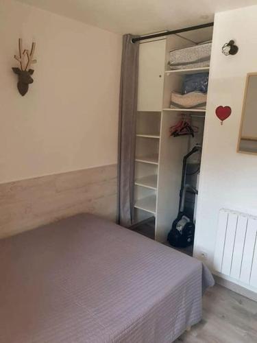 - une petite chambre avec un lit et un placard dans l'établissement Appartement T2 , 4/5 couchages Station Risoul 1850, à Risoul