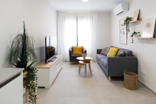 sala de estar con sofá y TV en Venegas Urban Suites By Bevacacional, en Las Palmas de Gran Canaria