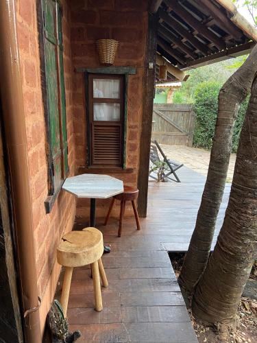 a patio with a bench and a table and a stool at Abrigo Cipó in Serra do Cipo