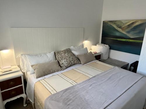 a bedroom with a bed and a painting on the wall at Somerset West Garden Apartments 2 in Somerset West