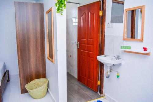 a bathroom with a red door and a sink at Dad's Place in Karatina