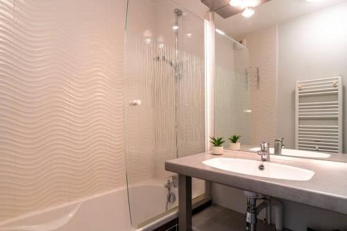 une salle de bain avec une douche, un lavabo et une baignoire dans l'établissement Les Thermes 404 - Appt proche plage avec piscine partagée, à Concarneau