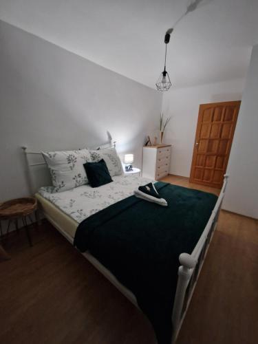 a bedroom with a large bed with a green blanket at Apartament Mar&Mel in Głuchołazy