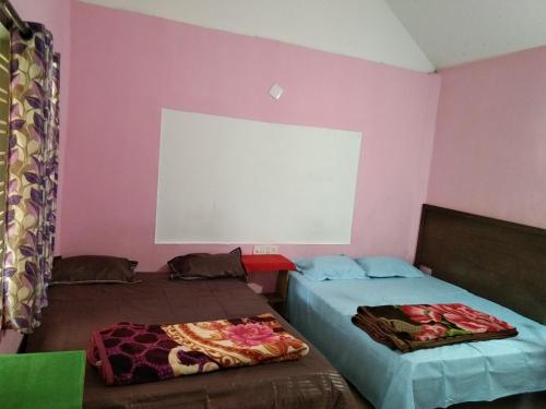 two beds in a room with pink walls at Munnar green portico cottage in Munnar