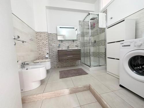 een badkamer met toilet, wastafel en wasmachine bij Mare Blu Apartament in Balestrate