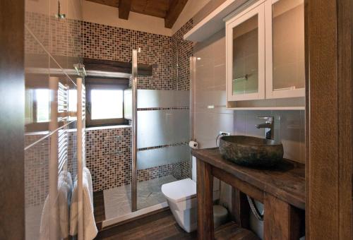 a bathroom with a sink and a glass shower at Egur Etxe I Caserío Vasco I Jardín I Porche I BBQ I Chimenea in Zárate