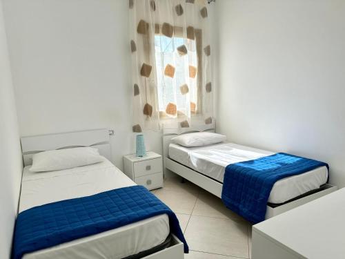 een slaapkamer met twee bedden en een raam bij Mare Blu Apartament in Balestrate